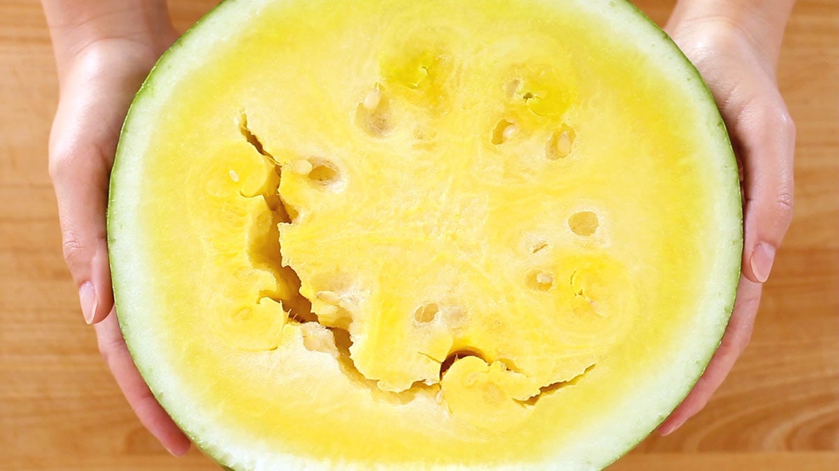 Top down view of a yellow crimson watermelon cut in half.